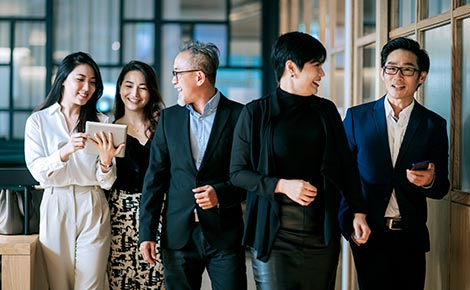 Five coworkers walking down the office hall.