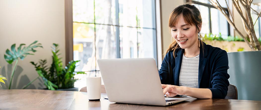 Woman using a laptop at a table.